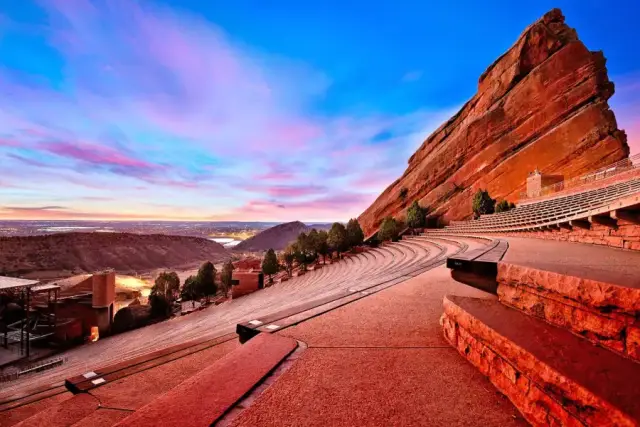 Red Rocks Amphitheatre at sunrise with Denver skyline in the distance